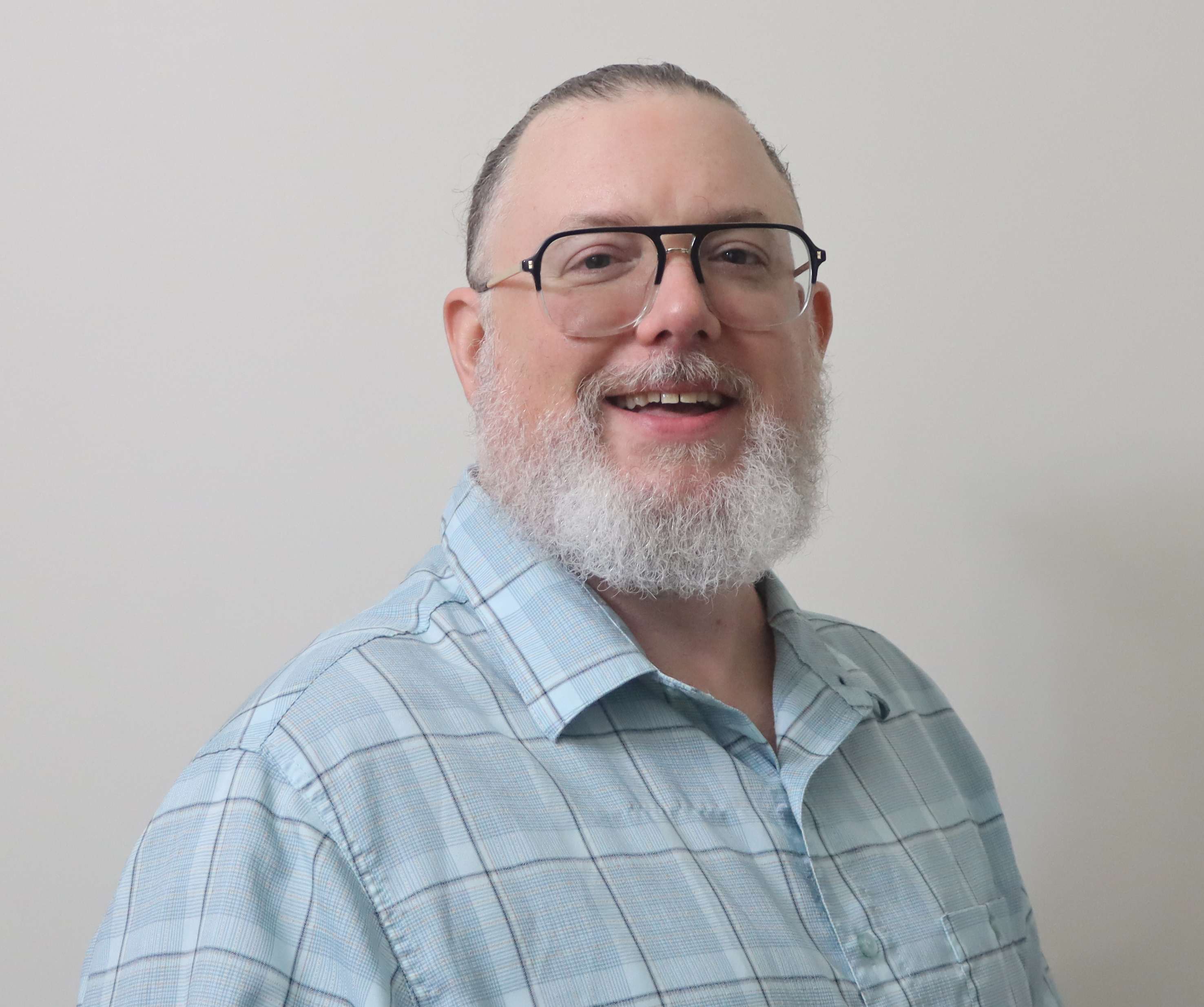Portrait of Jamie Fickes smiling in front of a neutral background